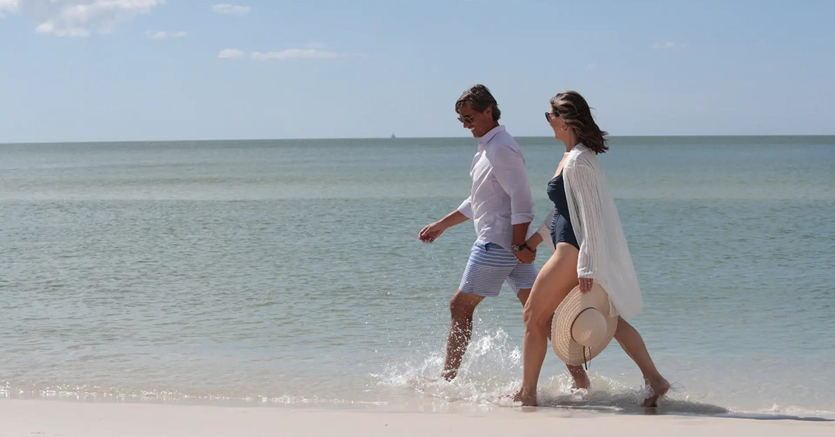 Couple walking along the shoreline of a Naples Florida beach