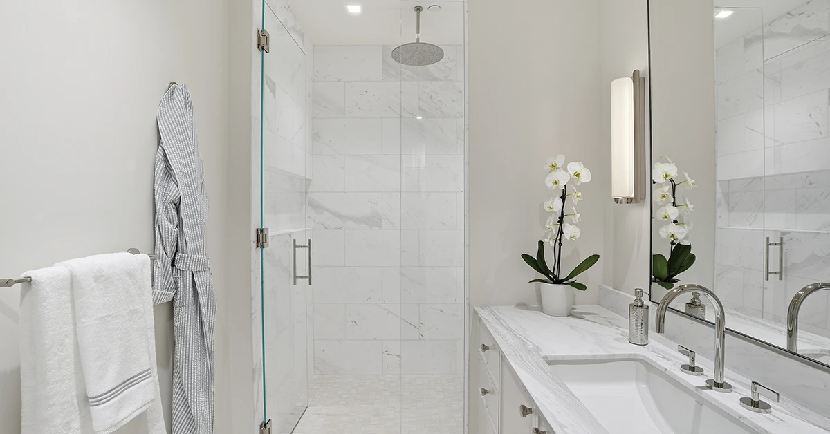 Modern marble bathroom with glass shower and vanity sink