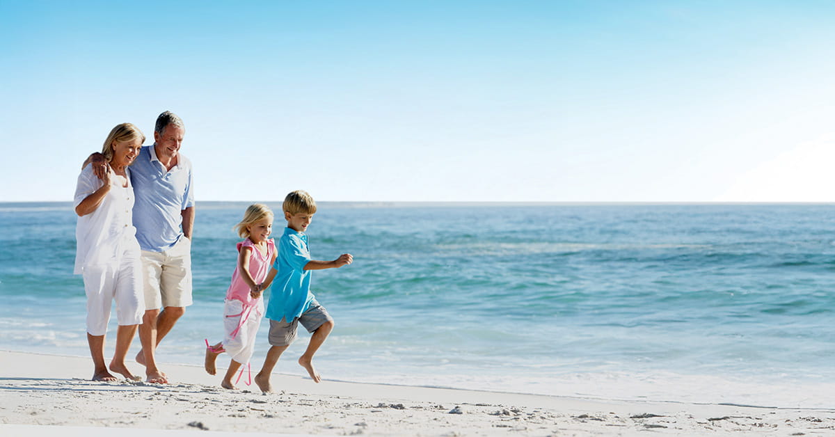 Family walking along beach with children near ocean shoreline